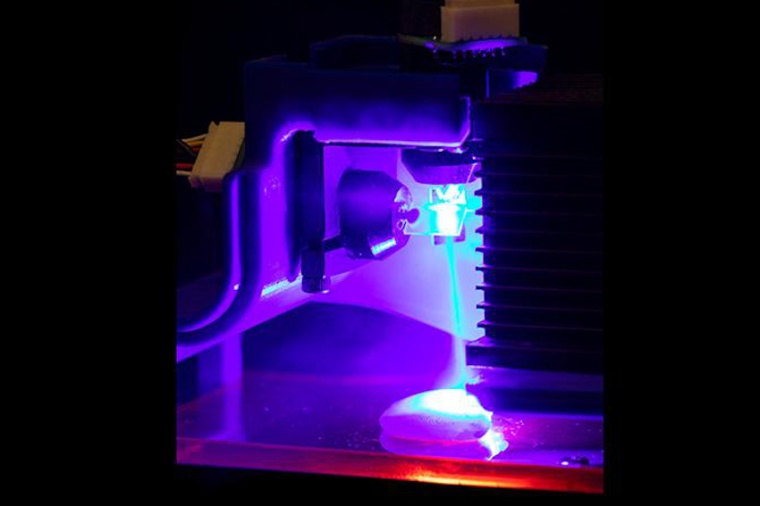 Chicken being cooked by a blue laser. Light is being directed by two...