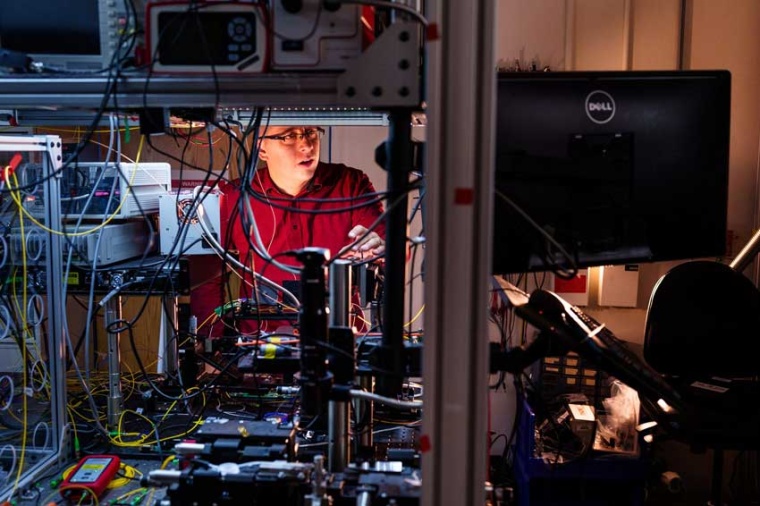 Nils Otterstrom aligns an integrated photonics chip at the quantum photonics...
