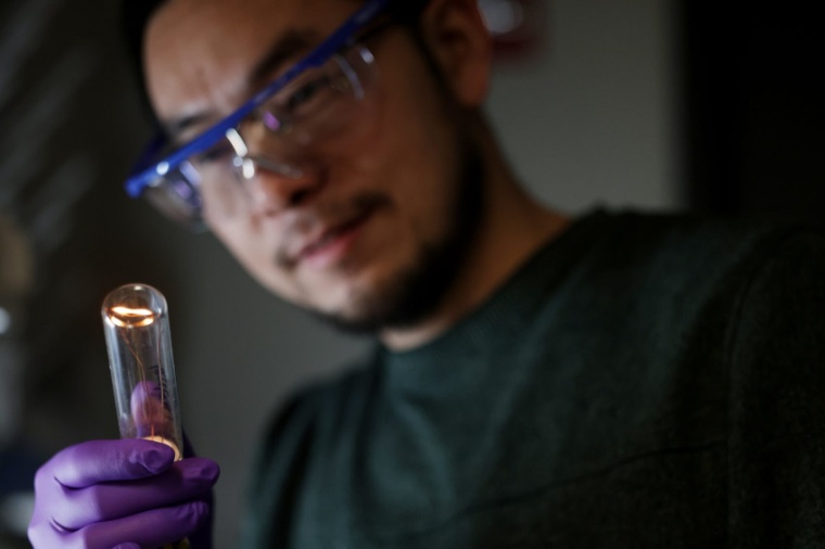 Jun Lu examines the twisted filament glowing within the bulb. He demonstrated...
