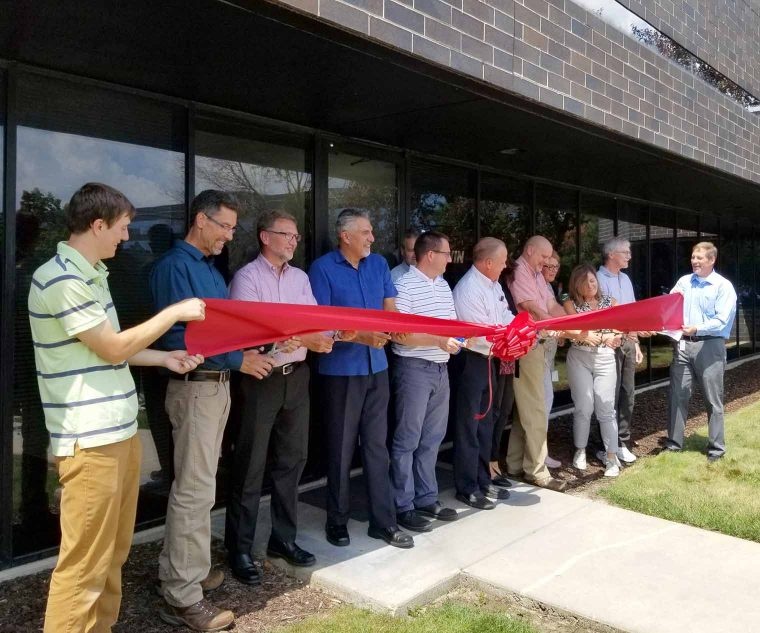 Langjährige Mitarbeiter nehmen an der Bandschneidezeremonie für die neue...