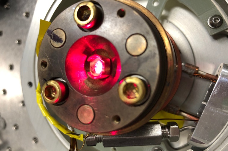 A strong laser is illuminating a material in a low-temperature chamber. The...