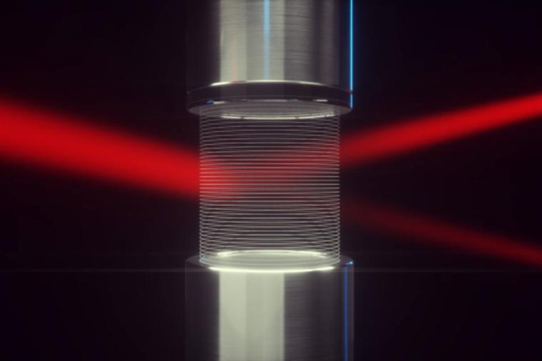 A laser light beam passes between a loudspeaker-reflector array that creates a...