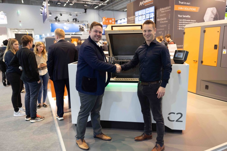 Jules Witte and Tobias Schamberger in front of a C2 machine on the Rösler / AM...