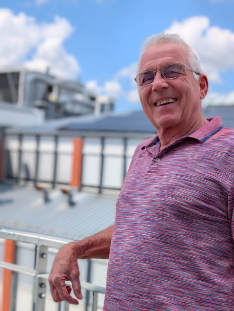 A portrait photo of Frank Schindler with the Excelitas factory in Göttingen in the background.